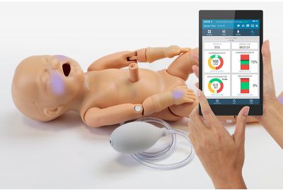 Premie Blue premature newborn patient simulator with SmartSkin and OMNI2 lying down with cyanosis on face and hands.