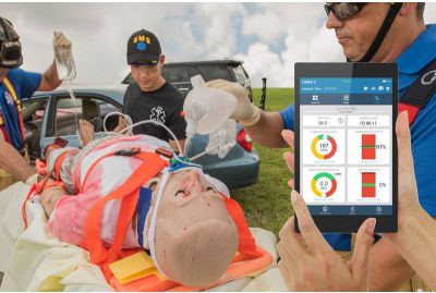 Trauma HAL patient simulator strapped to stretcher next to vehicle collision while paramedics deliver ventilations